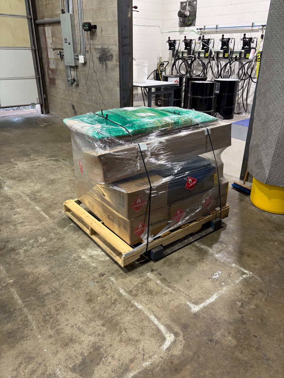 Shrink-wrapped hazmat-labeled pallet ready for freight pickup